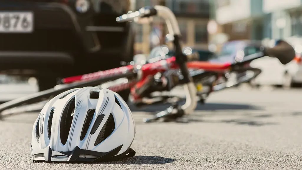 Qué es el seguro de responsabilidad civil: casco y bicicleta caídos tras un accidente urbano, ejemplo de daños a terceros cubiertos.